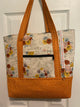 Cream background with orange/sky blue floral and orange polka dot base/straps